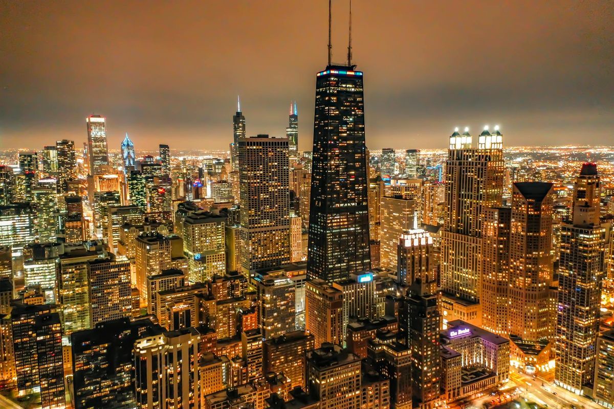 Illuminated nighttime city grid representing institutional complexity and mature scale